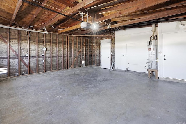 garage featuring strapped water heater and a garage door opener