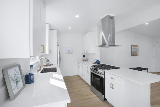 kitchen with light countertops, range hood, a peninsula, gas stove, and a sink