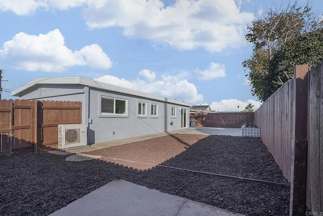 back of house with a patio area, stucco siding, a fenced backyard, and ac unit