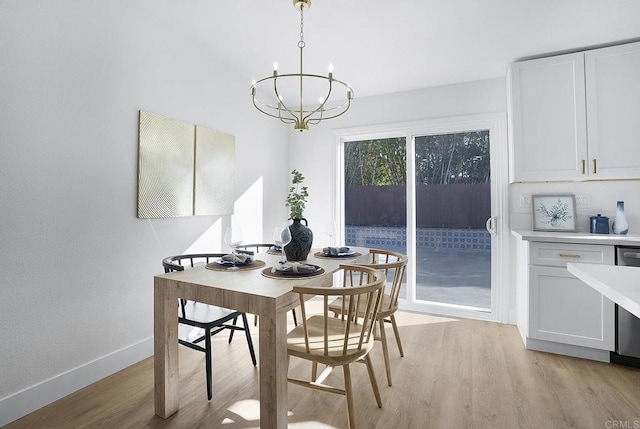 dining space featuring baseboards, light wood-type flooring, and a chandelier