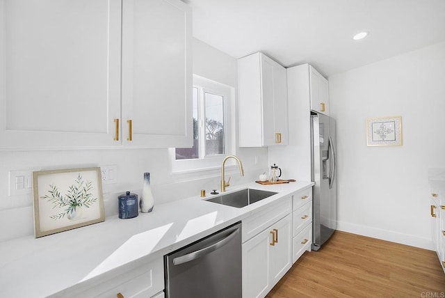 kitchen featuring a sink, light countertops, white cabinetry, and stainless steel appliances