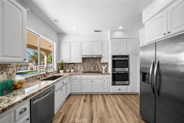 kitchen featuring tasteful backsplash, visible vents, appliances with stainless steel finishes, and a sink