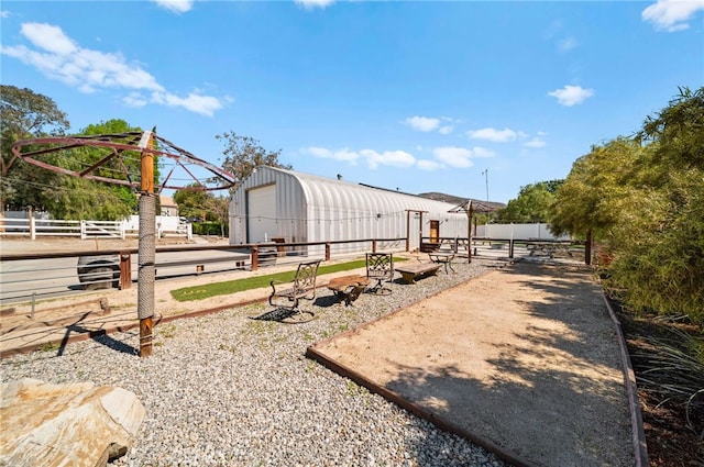 view of yard featuring a garage, an outbuilding, an outdoor structure, and fence