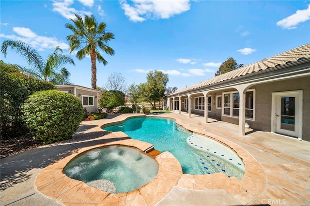 view of pool featuring a pool with connected hot tub and a patio area