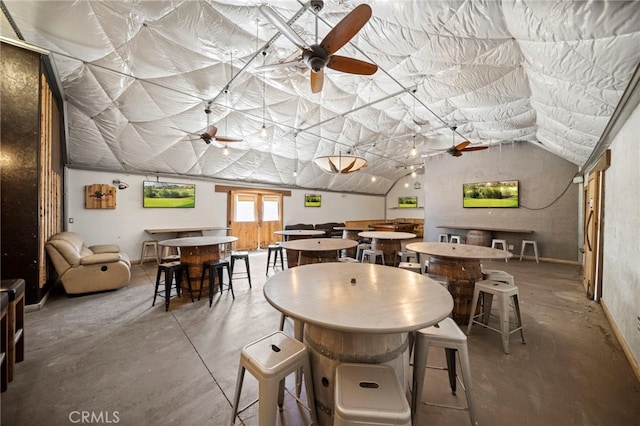 dining room with vaulted ceiling, a ceiling fan, and concrete flooring