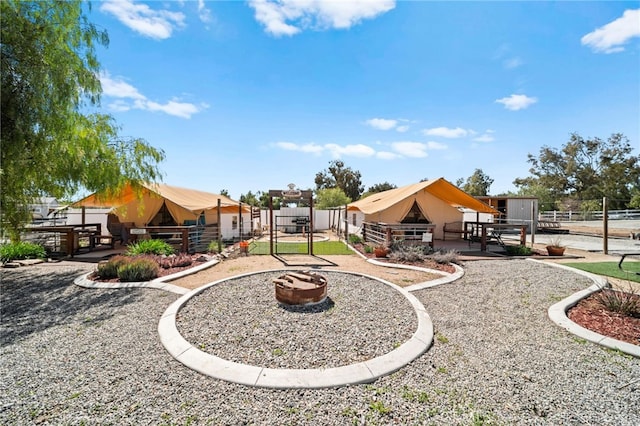 view of yard with a playground, fence, and a fire pit