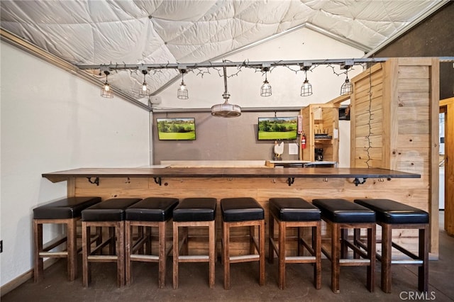 bar with bar area, concrete floors, and baseboards