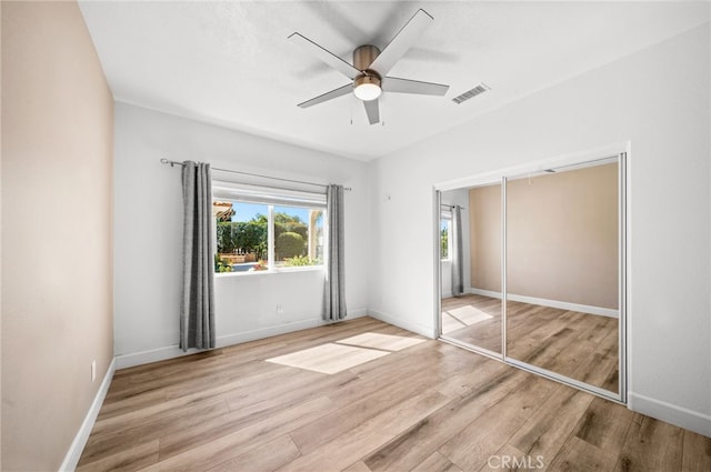 unfurnished bedroom with visible vents, baseboards, and wood finished floors