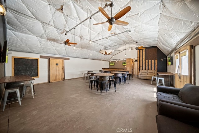 dining area with lofted ceiling, concrete flooring, and a ceiling fan