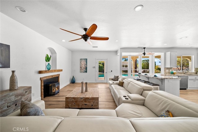 living area featuring a healthy amount of sunlight, light wood-style flooring, and a ceiling fan