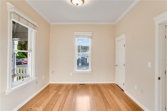 unfurnished room with light wood finished floors, visible vents, baseboards, and ornamental molding