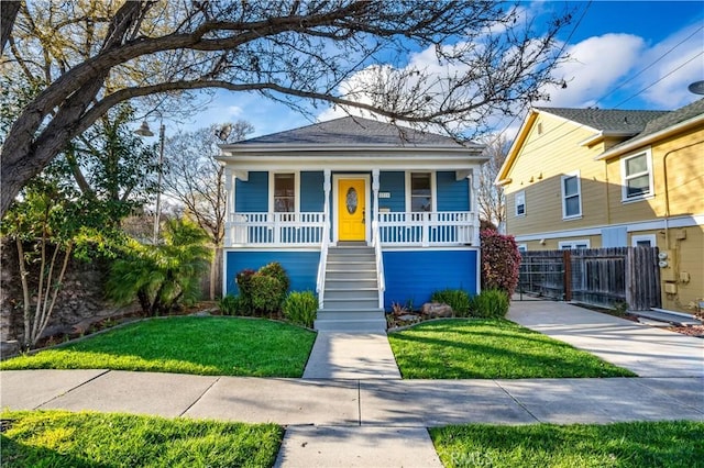 view of front of house featuring stairway, a porch, a front yard, and fence