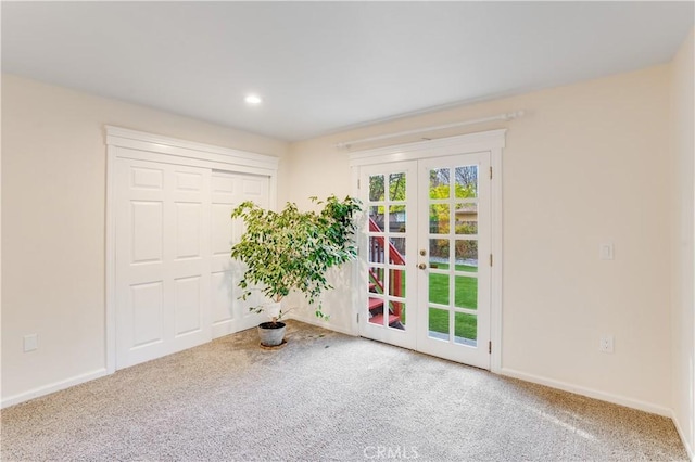 carpeted spare room with recessed lighting, french doors, and baseboards