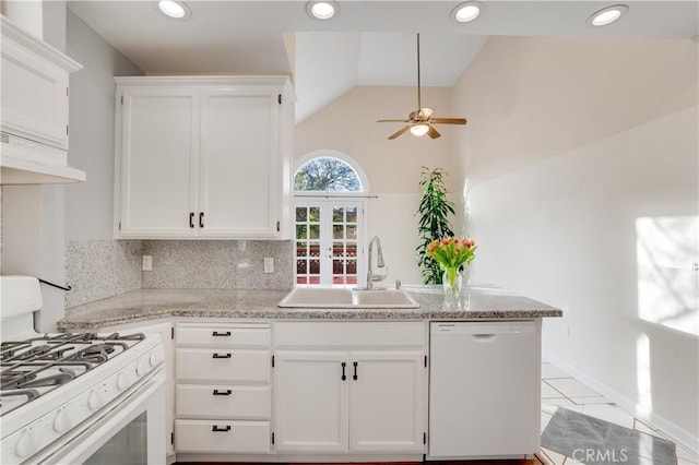 kitchen featuring under cabinet range hood, a peninsula, white appliances, a ceiling fan, and a sink