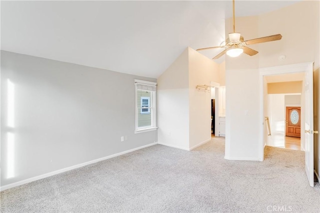 carpeted spare room featuring baseboards, ceiling fan, and vaulted ceiling