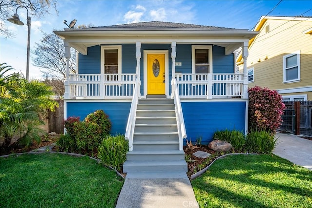 view of front facade featuring a porch, stairs, and a front yard