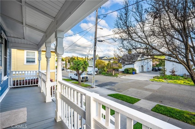 wooden terrace featuring a residential view and covered porch