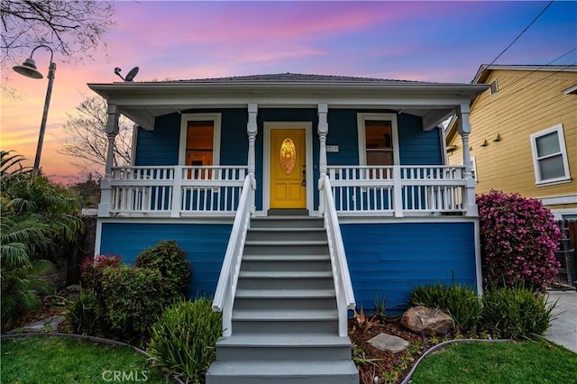 view of front of house with stairway and covered porch