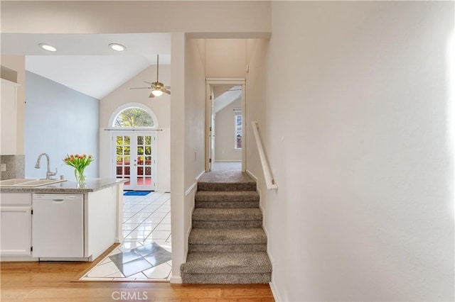 stairs with wood finished floors, recessed lighting, french doors, ceiling fan, and vaulted ceiling