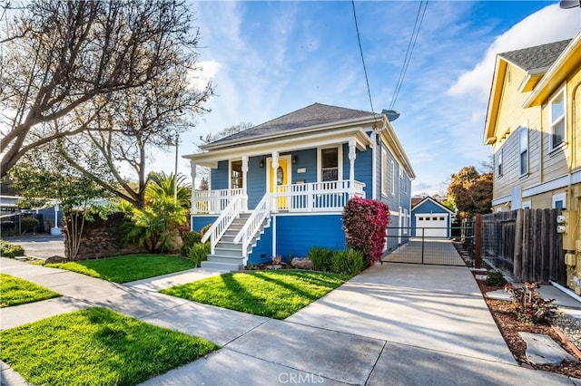 view of front of house with a detached garage, fence, a porch, an outdoor structure, and driveway