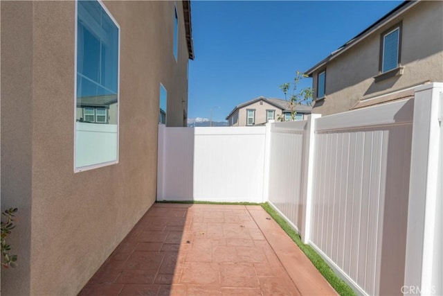 exterior space with fence, a patio, and stucco siding