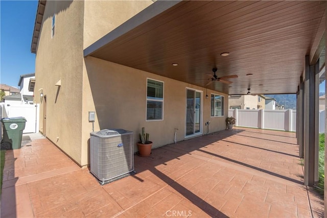 view of patio featuring central air condition unit, a ceiling fan, and fence