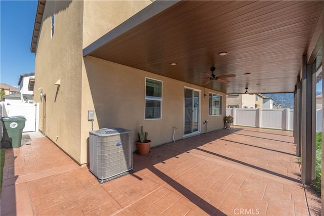 view of patio featuring central AC unit, fence, and a ceiling fan