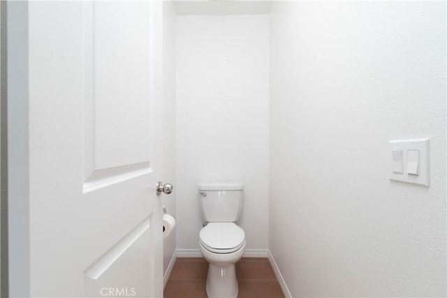 bathroom with tile patterned floors, toilet, and baseboards