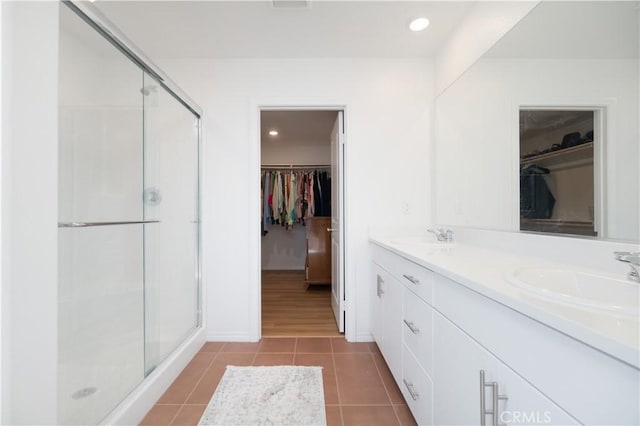 bathroom featuring tile patterned flooring, a shower stall, and a sink