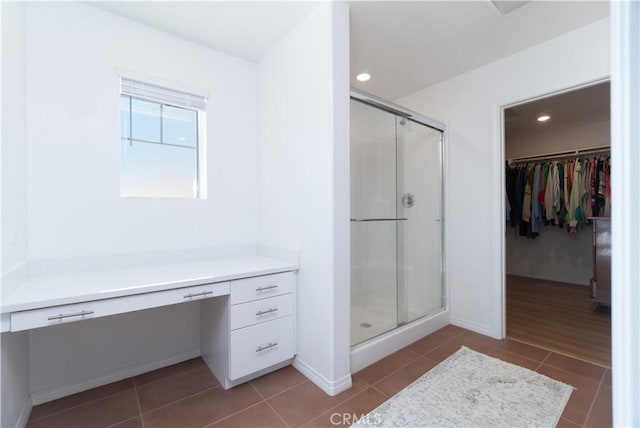 bathroom featuring baseboards, recessed lighting, a stall shower, tile patterned flooring, and a spacious closet