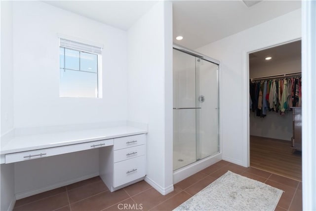 full bathroom with a spacious closet, tile patterned floors, a stall shower, and recessed lighting