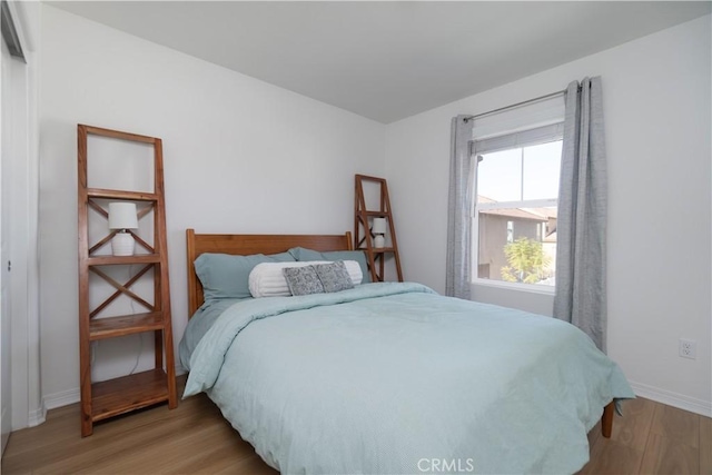 bedroom featuring light wood-style flooring and baseboards