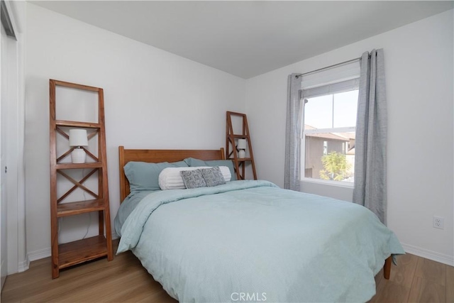 bedroom featuring baseboards and light wood finished floors