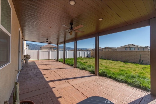 view of patio with a residential view, a fenced backyard, and a ceiling fan