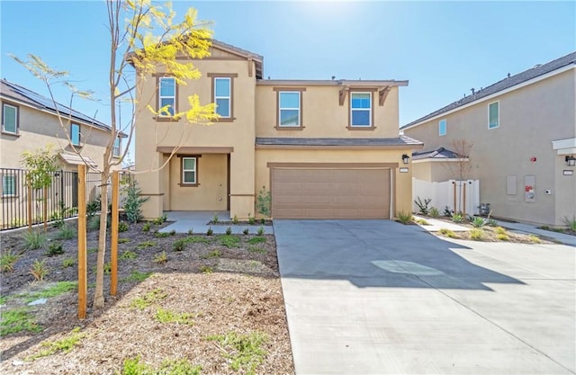 view of front of house with concrete driveway, fence, a garage, and stucco siding