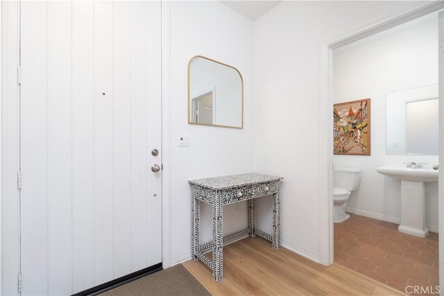 foyer entrance featuring light wood-type flooring and baseboards