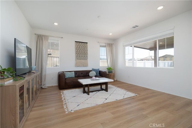 living room with recessed lighting, visible vents, baseboards, and light wood-style flooring