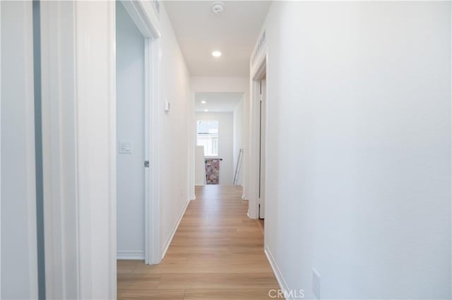 hall featuring recessed lighting, light wood-style flooring, and baseboards