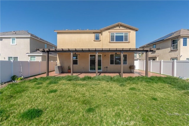 rear view of house featuring a yard, central AC, a fenced backyard, and stucco siding