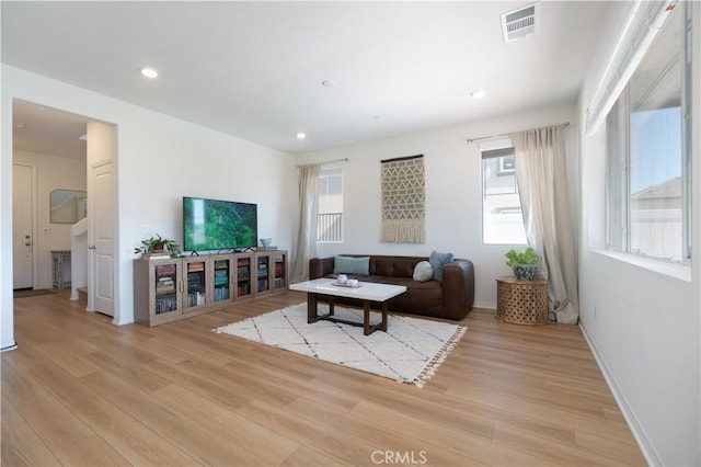 living area featuring recessed lighting, visible vents, and light wood finished floors