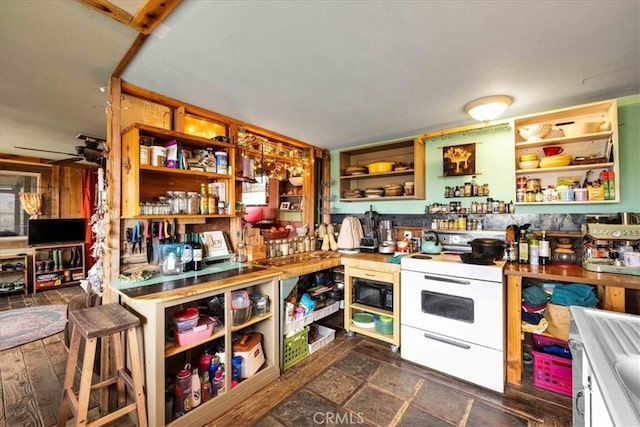 kitchen with white electric stove, stone finish flooring, and open shelves