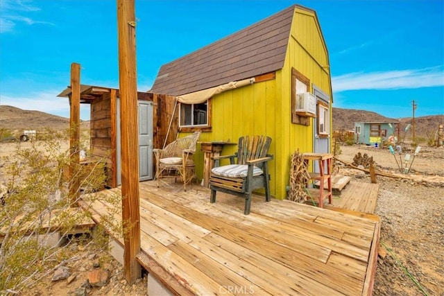 wooden deck with a mountain view and an outbuilding