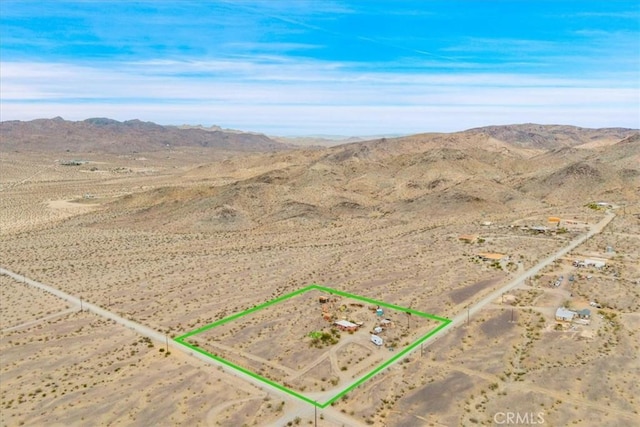 birds eye view of property featuring a mountain view and view of desert