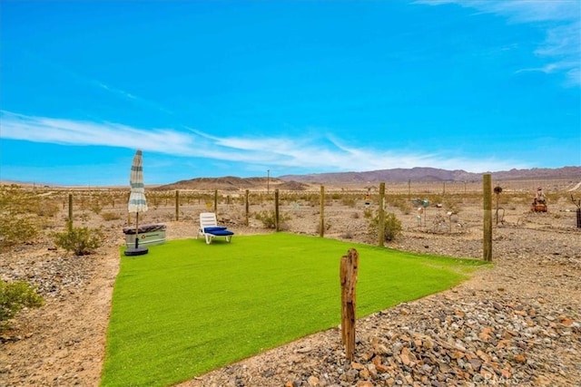 view of yard with fence, a mountain view, and a rural view