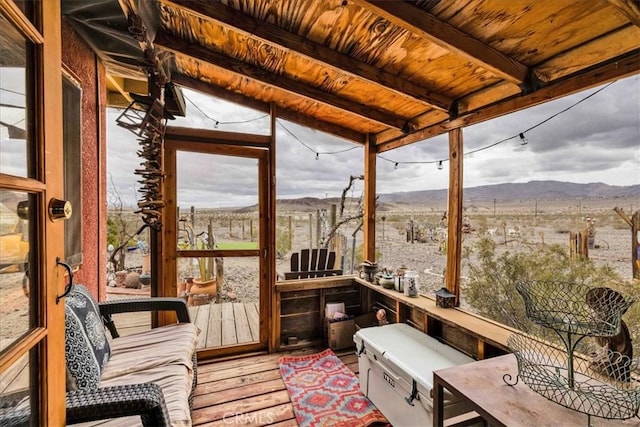 sunroom / solarium with a mountain view, wood ceiling, and beamed ceiling