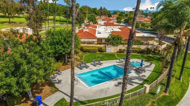 pool with a patio and fence