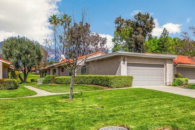 view of front of property with a front yard, concrete driveway, a garage, and stucco siding