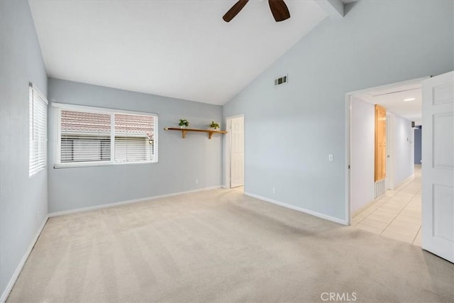 spare room featuring a ceiling fan, visible vents, light colored carpet, baseboards, and high vaulted ceiling
