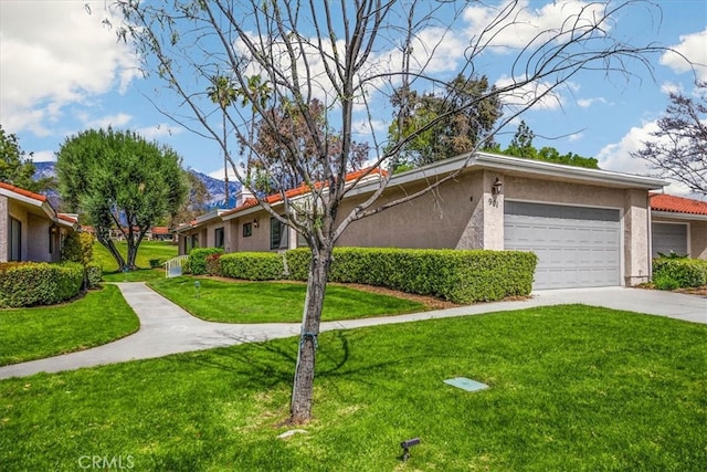 view of front of home with stucco siding, an attached garage, concrete driveway, and a front yard