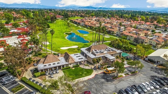 drone / aerial view with a residential view, view of golf course, and a water view